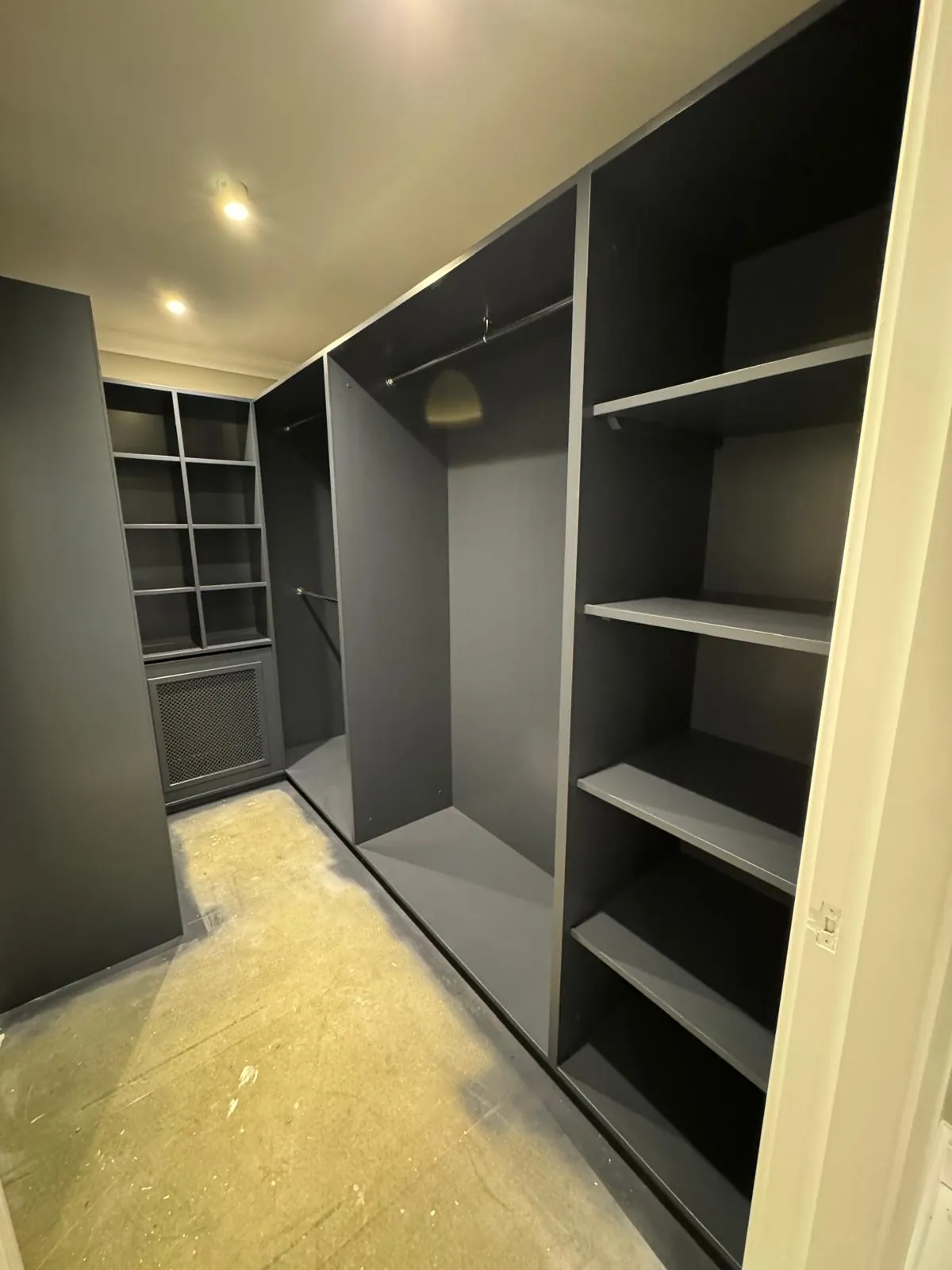 Walk-in wardrobe with open shelving and hanging rails, spray painted dark blue-grey